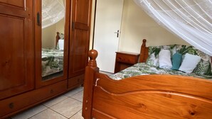Une chambre à coucher avec un lit en bois, une armoire et un lit à baldaquin.
