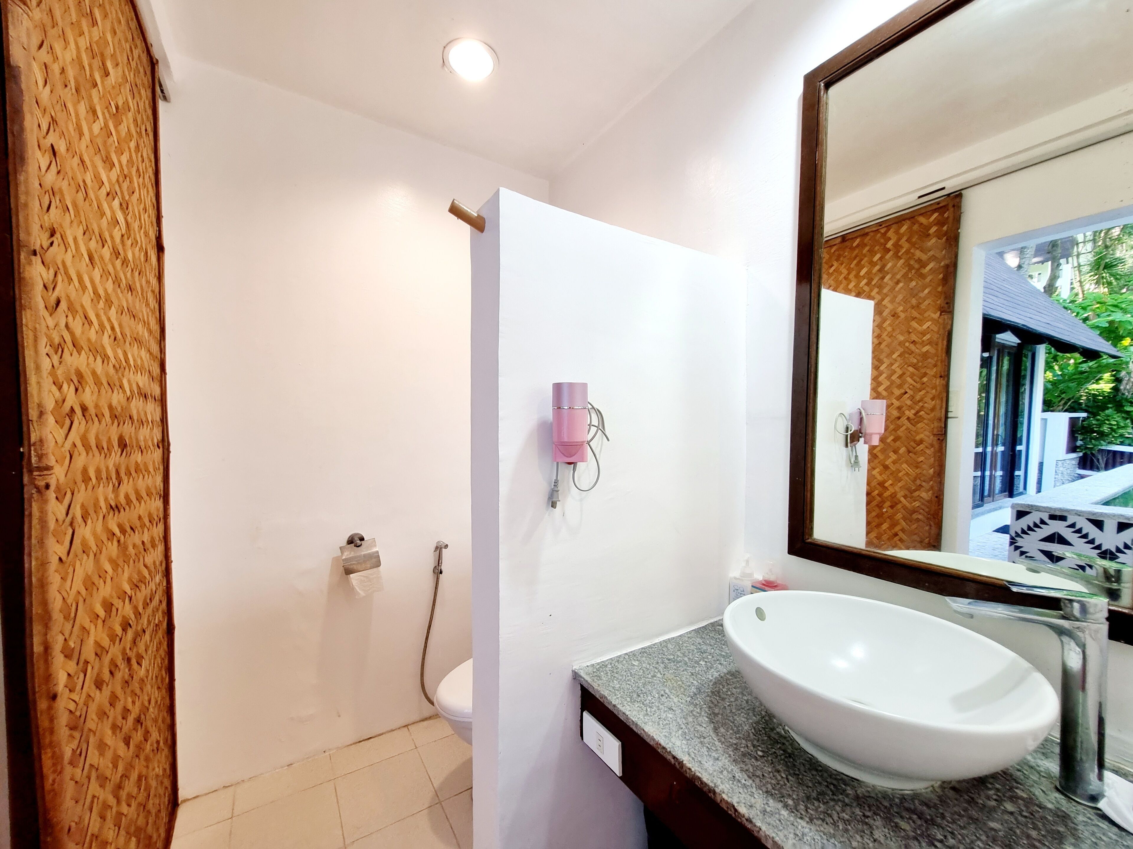 Une salle de bain avec un lavabo blanc, un miroir et une douche.
