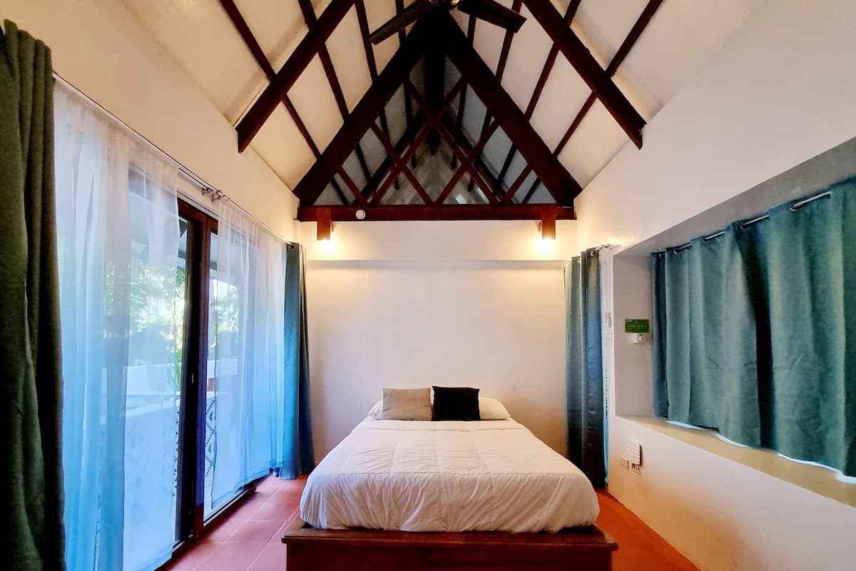 Une chambre à coucher avec un lit, une fenêtre et une vue sur l’extérieur.