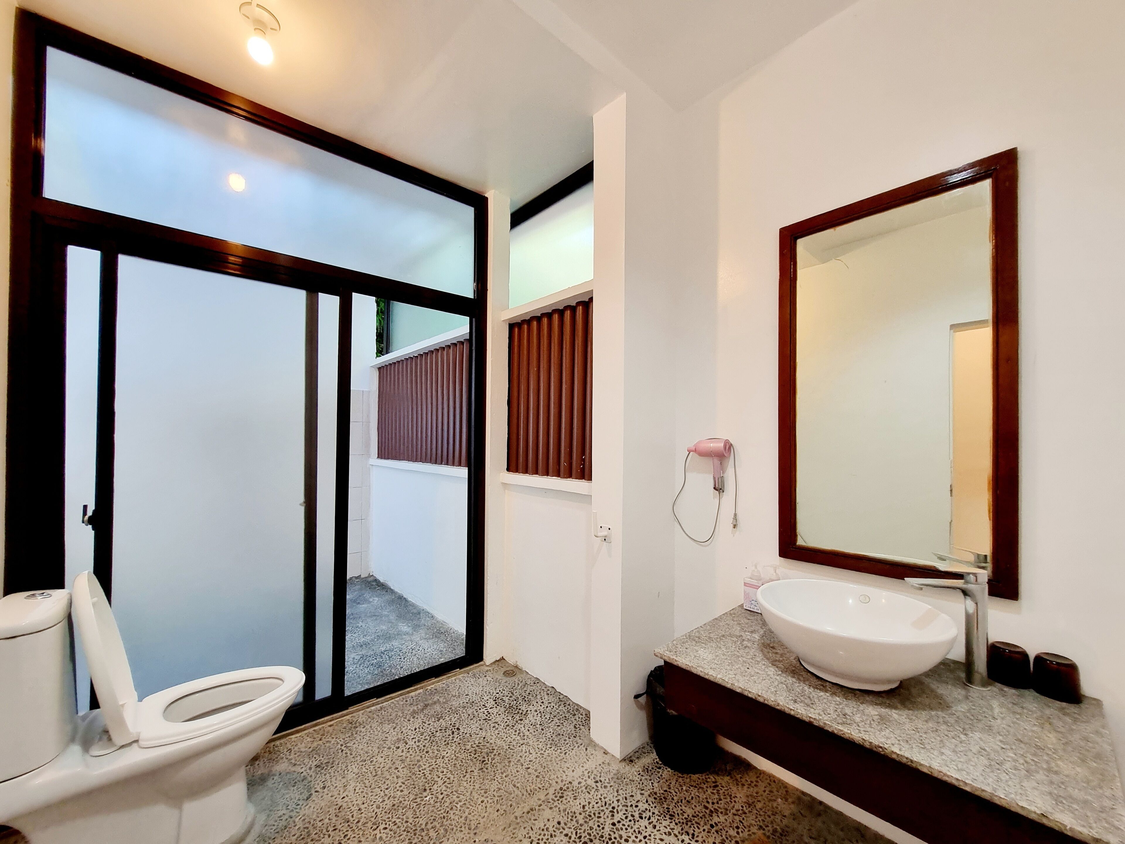 A bathroom with a toilet, a sink, and a mirror.