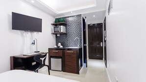 Quarto moderno com cama, mesa de cabeceira e escrivaninha com cadeira.