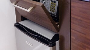 Uma kitchenette compacta com cafeteira, xícara e chaleira no balcão.