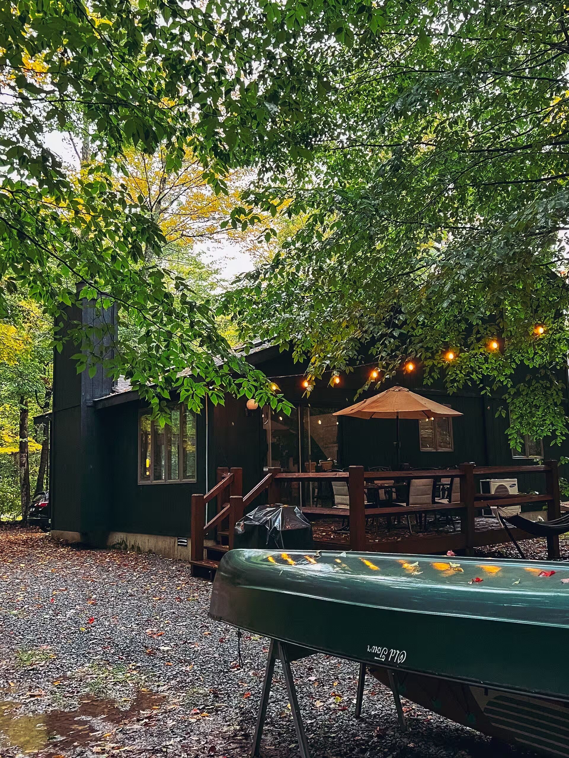 An outdoor seating area with tables and chairs, a covered patio, and a koi pond.