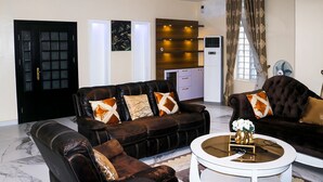 Ein modernes Wohnzimmer mit einem Ledersofa, einem runden Couchtisch und einem Schrank.