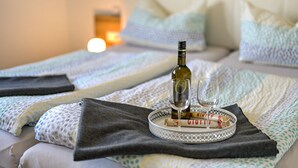 A neatly made bed with a bottle of wine, a glass, and a tray on it. - Apartment "Lieselotte, 72 sqm" with Balcony and Wi-Fi (Oberkirch)