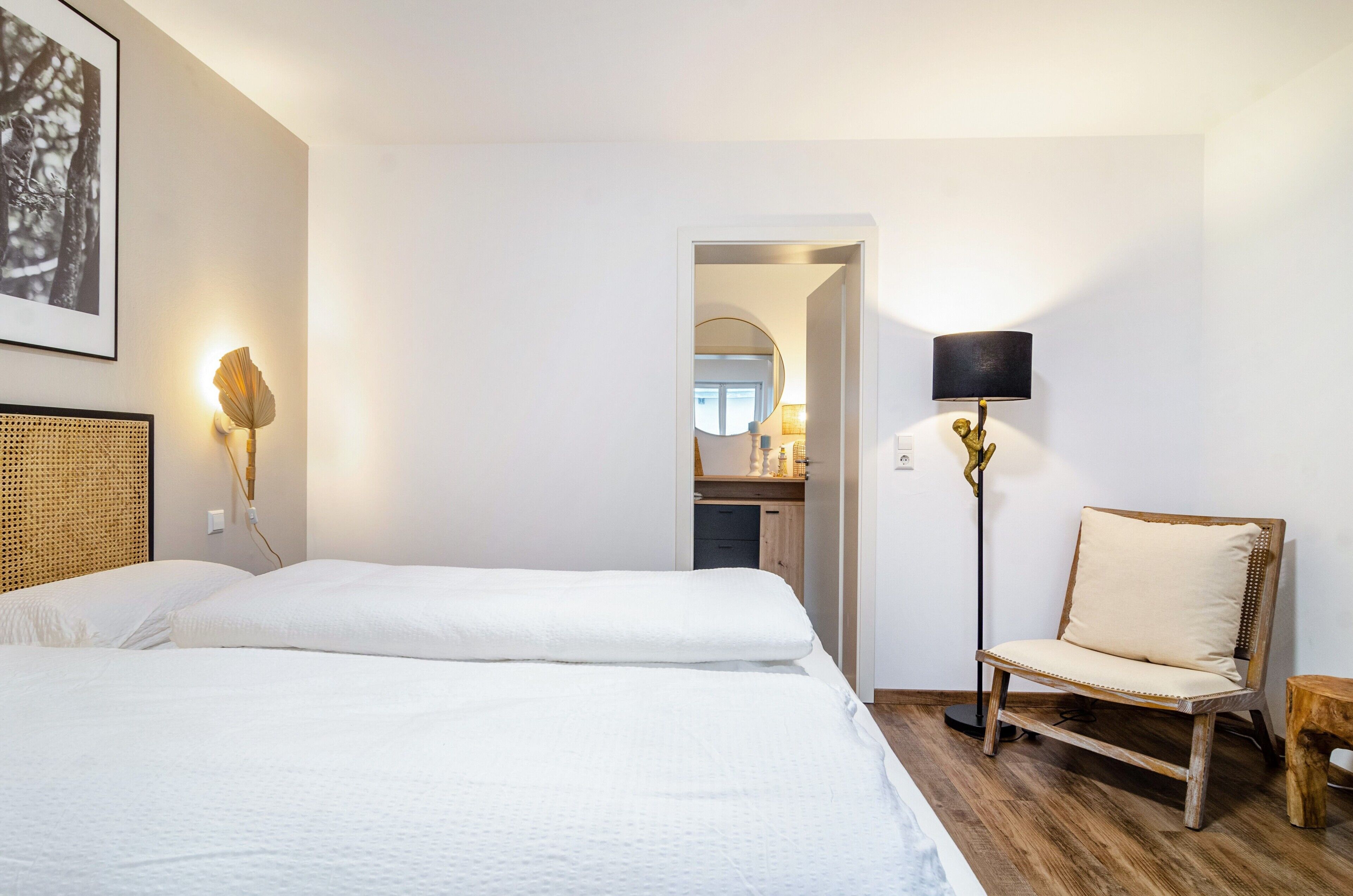 Una habitación de hotel con una cama, una silla, una lámpara y un cuadro en la pared.