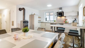 A modern kitchen with a central island, bar stools, and a dining table with placemats. - Holiday Apartment "Salem´s Treasure Manor" with Private Terrace, Shared Garden & Wi-Fi (Salem)