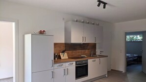 Een moderne keuken met witte kasten, een houten aanrechtblad en een ingebouwde oven.