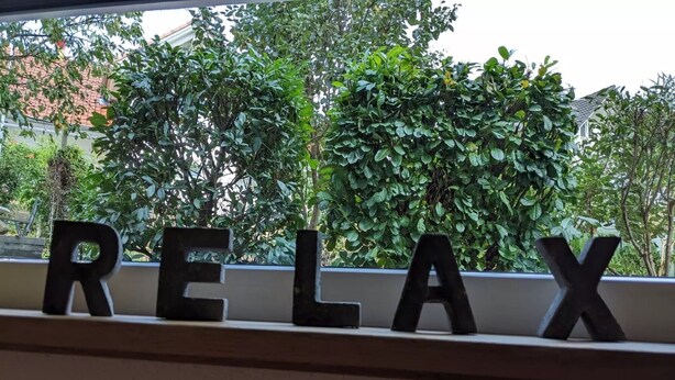 Een vensterbank met het woord 'RELAX' in zwarte letters.