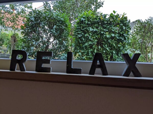 A window sill with the word 'RELAX' spelled out in black letters.