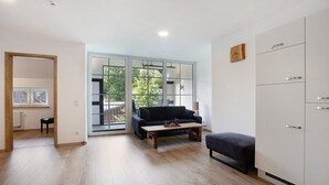 A modern living room with a sofa, a coffee table, and a cabinet. - Apartment 2, 65sqm, 2 bedrooms, max. 4 persons (Schmallenberg)