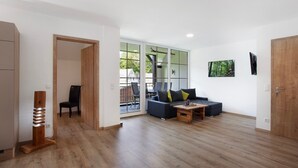 Ein modernes Wohnzimmer mit einer Couch, einem Couchtisch und einer Holzskulptur.
