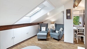 Un dormitorio estilo loft moderno con tragaluces, un sofá, una silla y un comedor.
