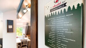 Un panel de menú con una lista de platos y sus descripciones en alemán.