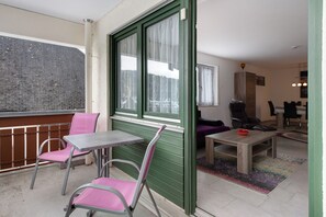 A balcony with a table and chairs, a dining area with a table and chairs, and a view of a brick wall. - Holiday Apartment "Todtmoos" with Mountain View, Balcony & Wi-Fi (Todtmoos)