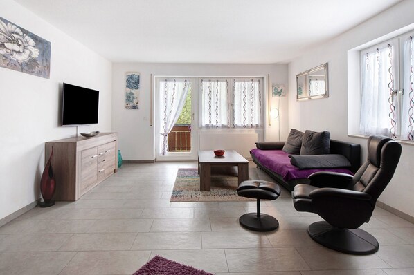 A living room with a TV, sofa, coffee table, and a chair. - Holiday Apartment "Todtmoos" with Mountain View, Balcony & Wi-Fi (Todtmoos)
