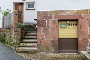 Un edificio de piedra con una puerta de madera y un cartel encima.