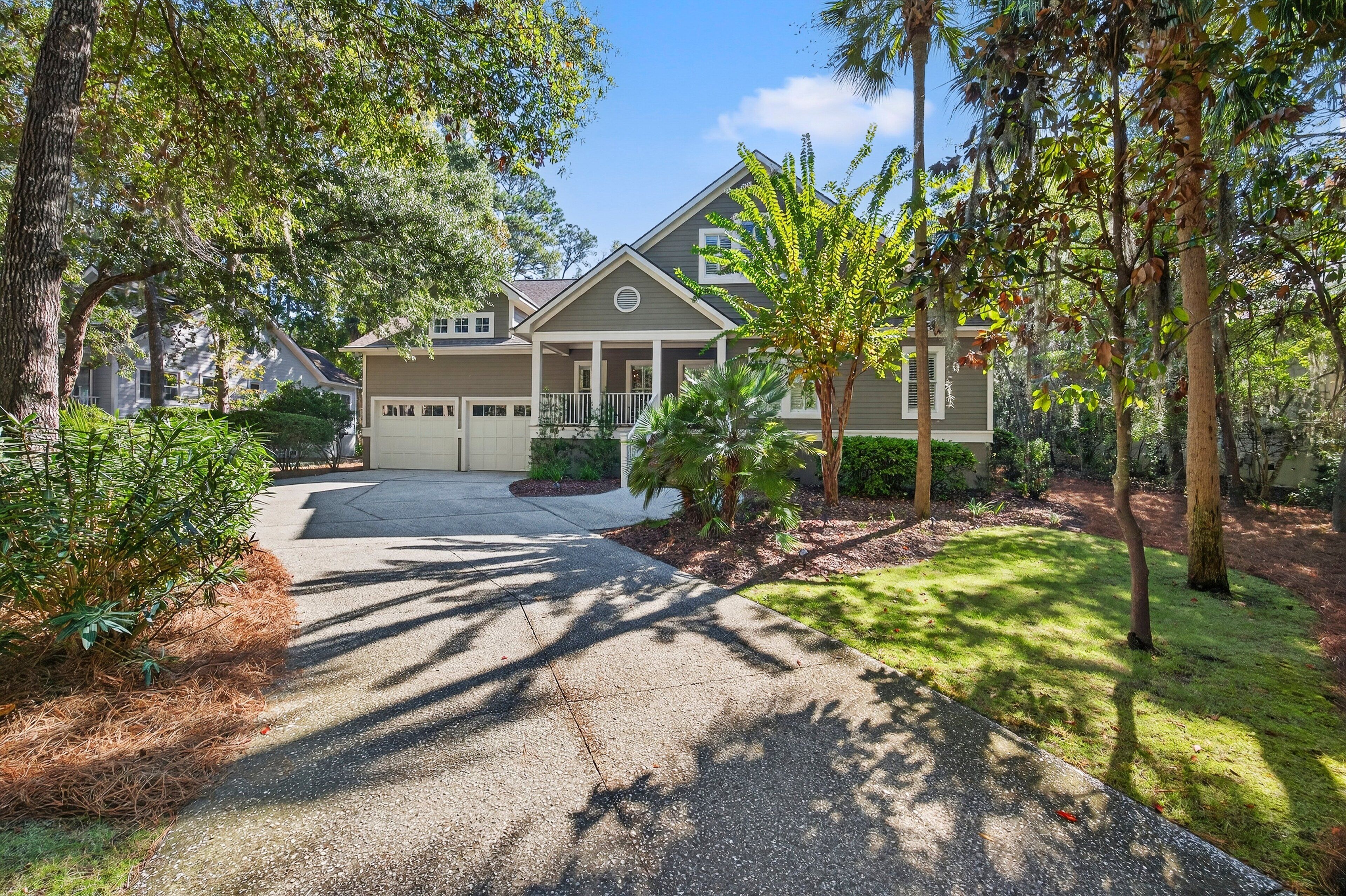 A two-story house with a front porch, a garage, and a well-maintained lawn.