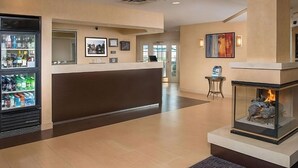 A hotel lobby with a reception desk, a fireplace, and a refrigerator stocked with beverages. - Spacious Accommodation in Charleston! W/ Private Kitchenette! Pets are Welcome! (Charleston)