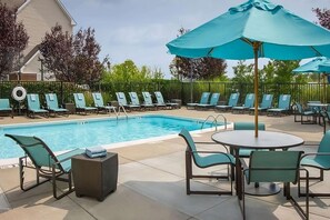A pool area with lounge chairs and umbrellas, surrounded by a fence and greenery. - Spacious Accommodation in Charleston! W/ Private Kitchenette! Pets are Welcome! (Charleston)