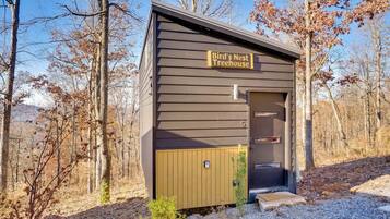 A small, single-story building with a sign reading "Bird's Nest Treehouse."