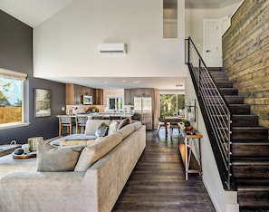 Relax in this spacious living area with a large sofa and modern kitchen.