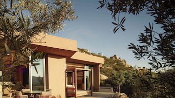 Uma casa moderna com área de varanda, janelas amplas e vista para a paisagem ao redor.
