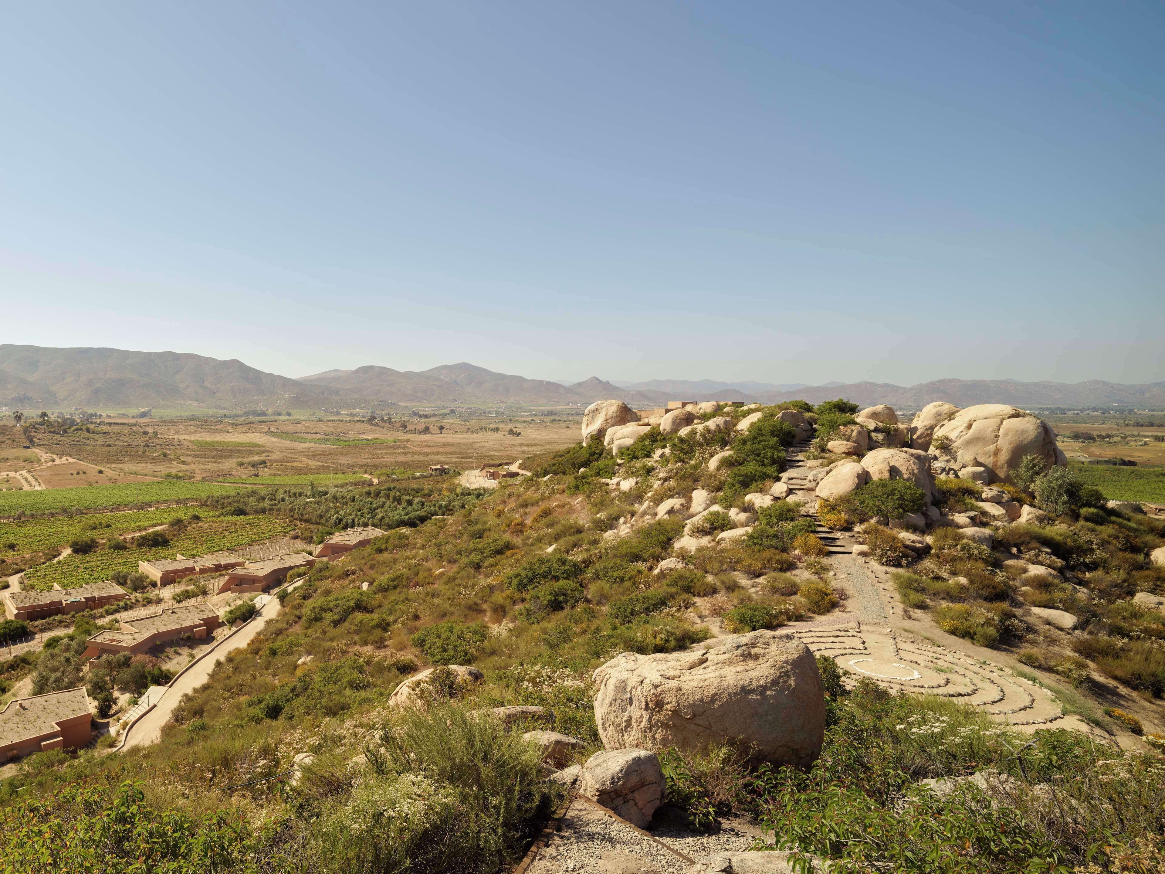 A hilly landscape with large boulders and a winding path.