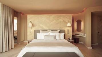 Una habitación de hotel moderna con una cama grande, dos lámparas de noche, un espejo redondo y un banco.