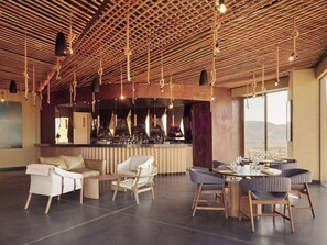 A spacious lounge area with a bar, seating arrangements, and a view of the outdoors.