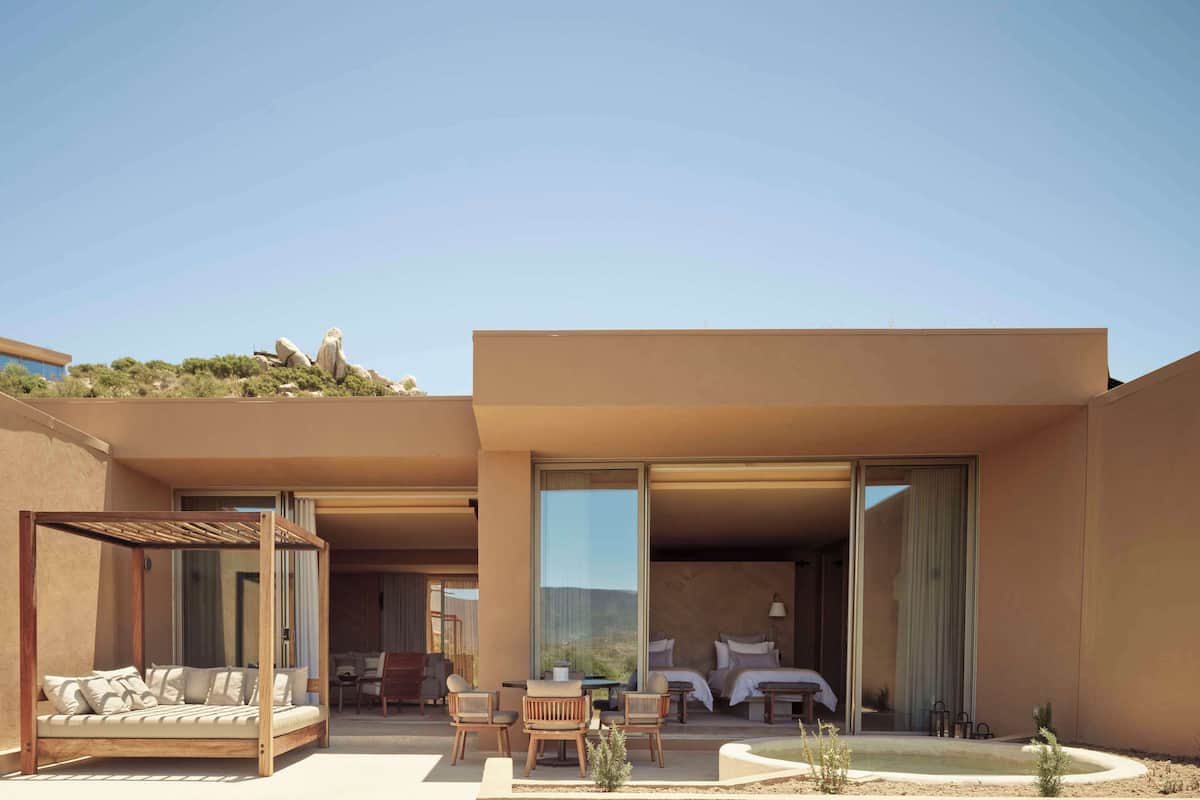 A modern outdoor living area with a sofa, chairs, and a small table.