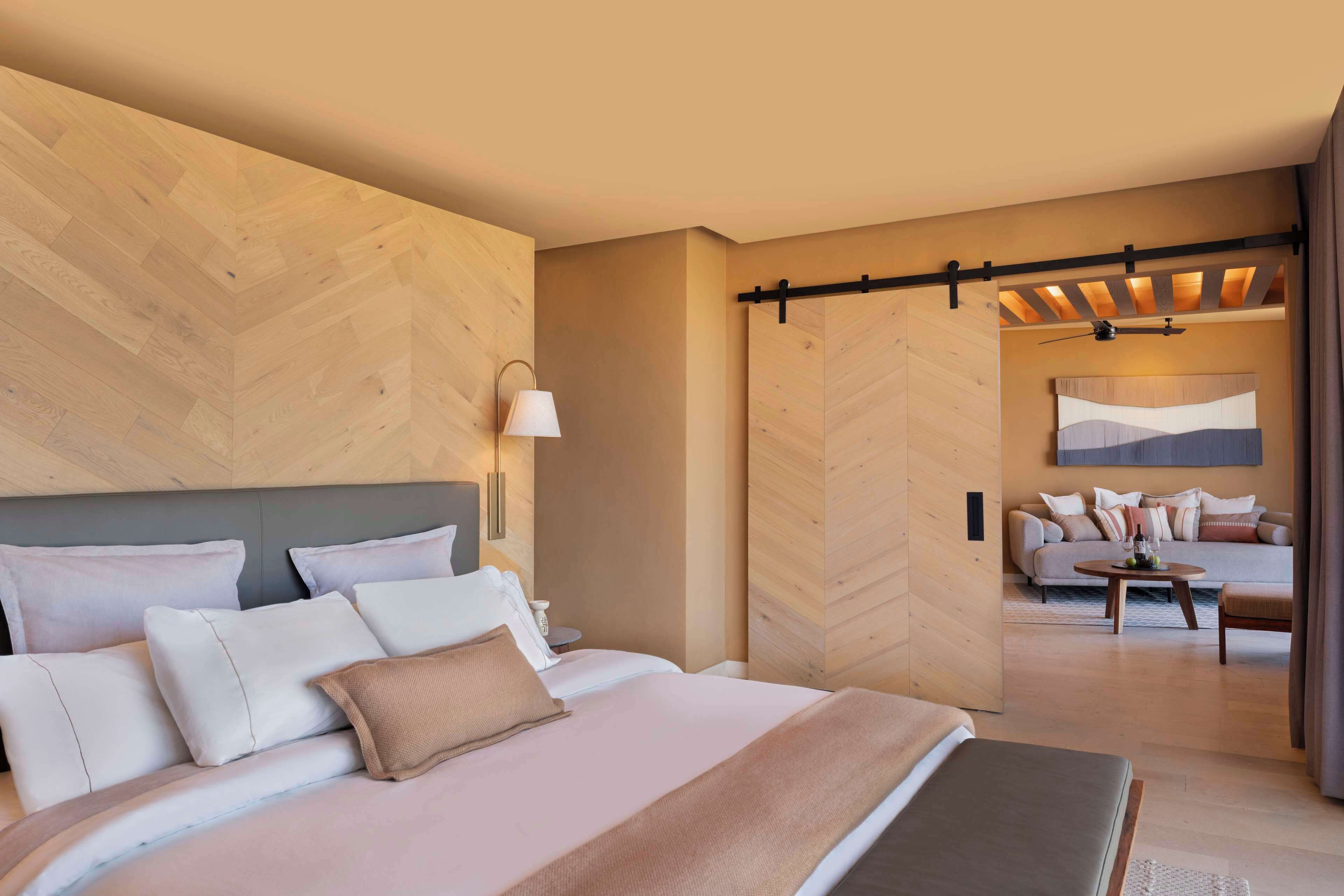 Een moderne hotelkamer met een groot bed, een slaapbank en een zithoek.