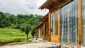 Un bâtiment en bois doté de grandes fenêtres et d’une entrée pavée de pierres.