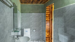Une salle de bain avec un lavabo blanc, un miroir et un sol carrelé.
