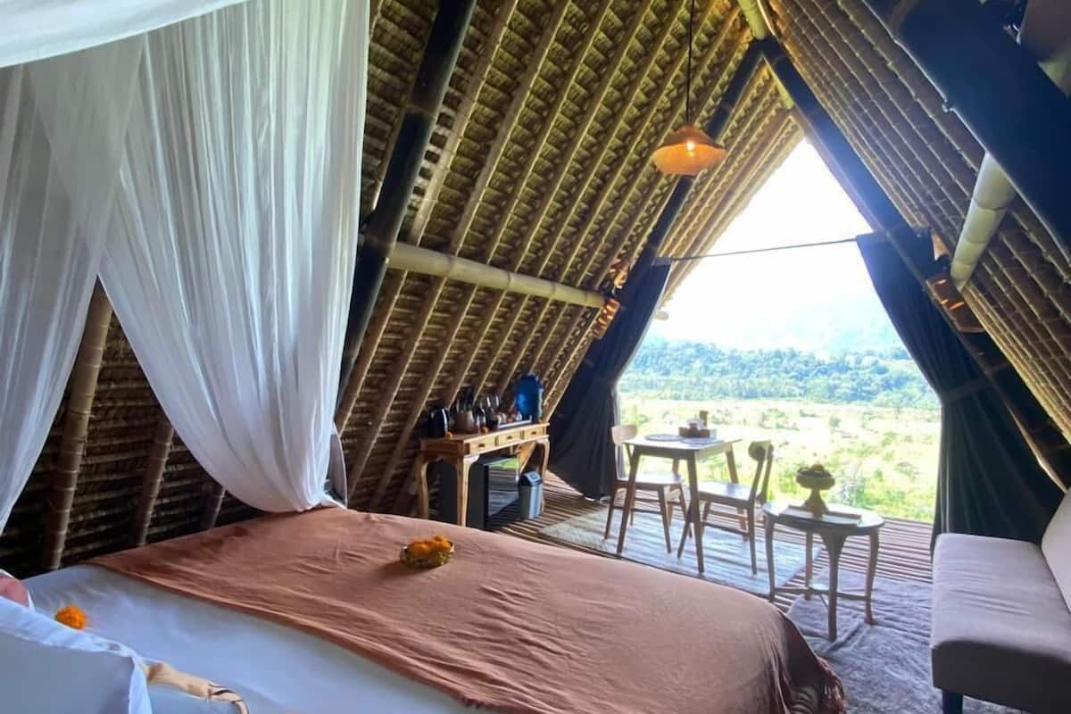 A cozy, elevated bedroom with a bed, a table, and chairs.
