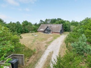 Situated in a lush environment, this traditional house features a small porch and chimney.