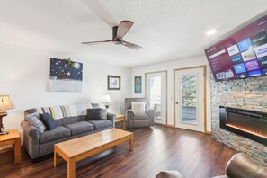 A living room with a sofa, armchair, coffee table, and fireplace. - Wisconsin Dells Escape - Amazing Views - Pools (Wisconsin Dells)