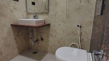 A bathroom with a sink, toilet, and mirror.
