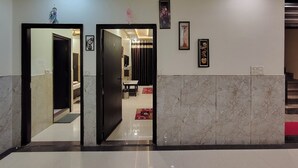 Un vestíbulo de hotel con suelo de mármol, una recepción y una escalera.