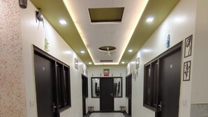 Un pasillo limpio y bien iluminado con suelo de baldosas, que conduce a una puerta al final.