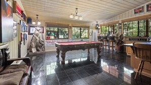 A billiards room with a pool table, wooden ceiling, and large windows. - Hot Tub Hideaway - Game Room - Near Kirkwood (West Point)