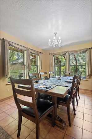 A dining area with a wooden table, chairs, and a chandelier.