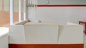 A room with a large white and orange box, a red and white striped wall, and a window.