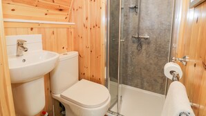 A wooden interior bathroom with a sink, toilet, shower, and bathtub. - Llugwy Pod (Llanrwst)