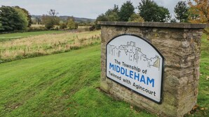 A stone sign with a town map and text indicating it is the Middleham and Agincourt twin towns. - Teal Cottage (Leyburn)