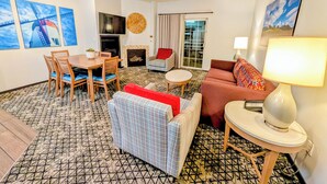 A hotel room with a dining area, a sofa, a red chair, a lamp, and a fireplace. - 3BR: Danish-Style Retreat in CA Wine Country (Solvang)