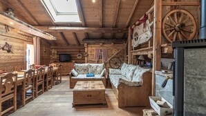 Un interior rústico de madera con chimenea, muebles de madera y un televisor.