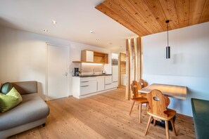 Un espacio moderno para vivir con sofá, mesa de comedor, sillas y una zona de cocina.