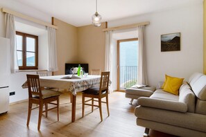 Uma sala de jantar com mesa, cadeiras e sofá.