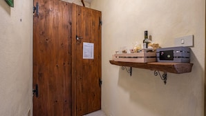 A wooden double door with a paper on it, a shelf with food items, and a power outlet on the wall. - Farmhouse "Gufo" with Shared Pool, Private Terrace & Wi-Fi (Pitigliano)